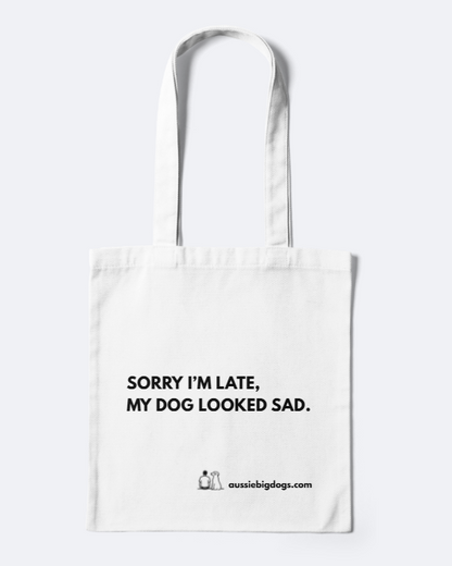 White tote bag with text 'Sorry I'm late, my dog looked sad.' on a white background
